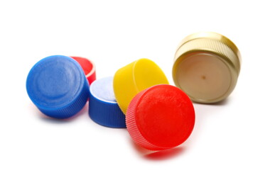 Colorful plastic bottle caps pile isolated on white background