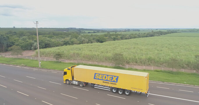 Ribeirao Preto, Sao Paulo / Brazil - Circa January 2019: Aerial image of a yellow Brazilian postal truck traveling on the highway. Delivery of postage by country.