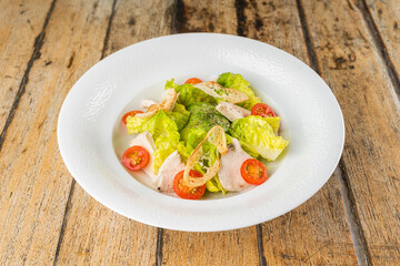 Green avocado salad with chicken on wooden table