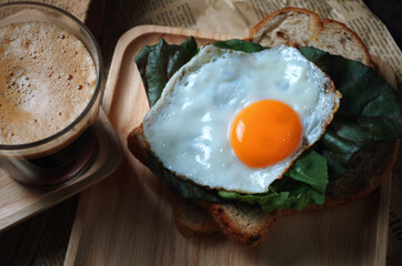 Fried egg on the vegetable and bread for breakfast