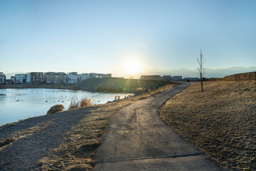 Direct sunlight at the sidewalk along the lake near the residential area