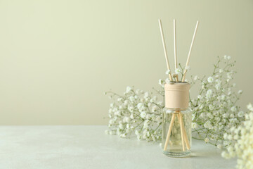 Diffuser and flowers on white textured table