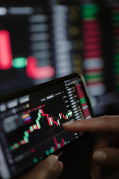 mano de mujer empresaria analizando los gr&aacute;ficos del mercado de la bolsa y criptomonedas en el tel&eacute;fono m&oacute;vil y ordenador