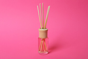 Aroma scent diffuser with sticks on pink background