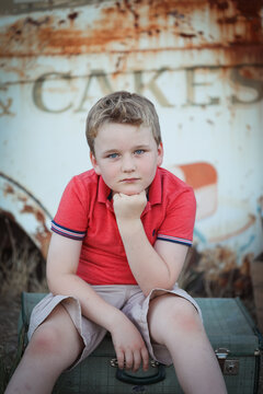 Beautiful portrait image of young caucasian boy sitting with chin resting on hand