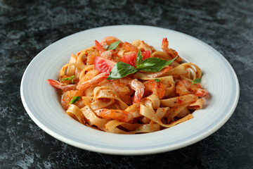 Concept of tasty eating with shrimp pasta on black smokey table