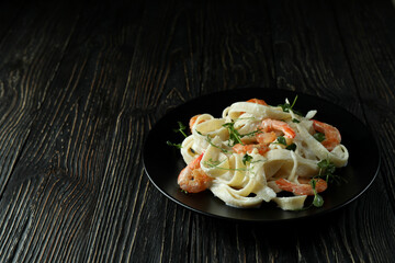 Plate of shrimp pasta on rustic wooden background