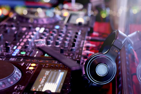 DJ headphones on controller turntable console mixing desk at stage in the night club, music beach party festiva and nightlife concept.