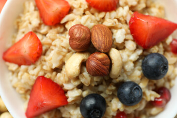 Fresh cooked oatmeal with fruits, close up