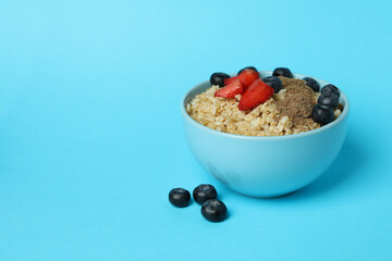 Concept of tasty eating with oatmeal on blue background