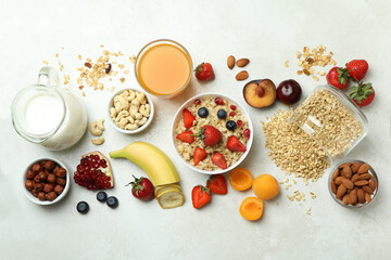 Bowl of oatmeal and ingredients for cooking on white background