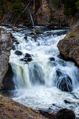 Flowing waterfall in blurry motion over black rock river.