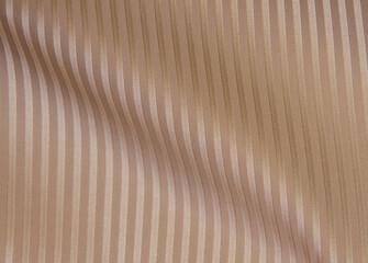 Crumpled beige striped fabric. Fabric texture,background for design.