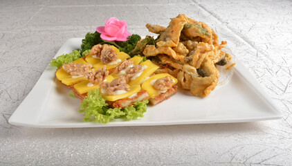 Deep fried egg skin crepe with mango fruit, walnut and salted egg yolk fish skin platter in white background appetiser halal menu