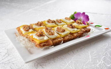 Deep fried egg skin crepe with mango fruit, walnut and salted egg yolk fish skin platter in white background appetiser halal menu