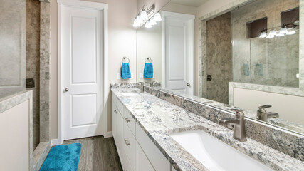 Pano Bathroom with long vanity with two sinks and walk-in shower with half wall and glass