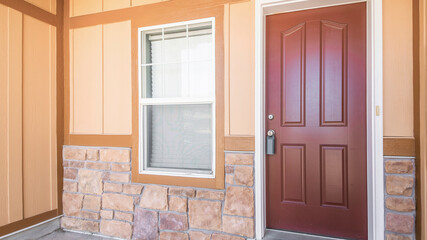 Pano Front door exterior of a house with half stone and wooden wall