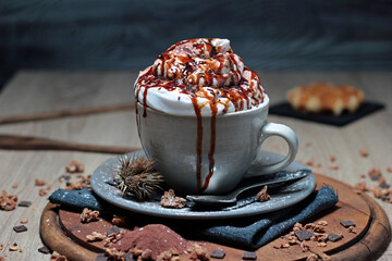 delicious and appetizing cup of cappuccino with whipped cream and caramel sauce and chocolate topping