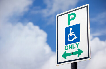 Wheelchair Only Parking sign in a cloudy blue sky