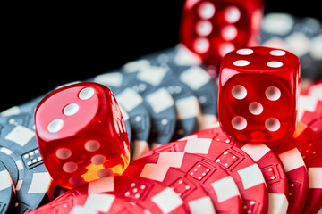 Red casino dice and chips isolated over black reflective background