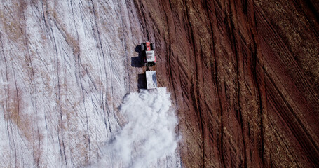 Tractor applying limestone to the soil to correct acidity