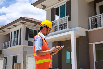 Asian male foreman builder uses tablet to supervise construction for modern construction technology