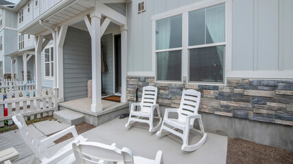 Pano Patio in front of a townhouse with wooden white fence and rocking chairs