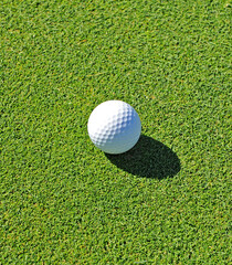 Close-up of a white golf ball on a green grass background. Golf concept on a golf course. Playing golf ball in green. 