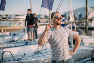 Fototapeta na wymiar Tourist walks on sailing yachts. Male tourist on vacation on a boat at the sea.