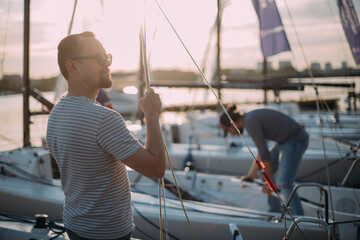 Fototapeta na wymiar Tourist walks on sailing yachts. Male tourist on vacation on a boat at the sea.