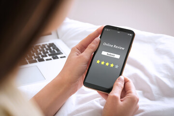 Woman using smartphone to give feedback indoors, closeup. Customer review