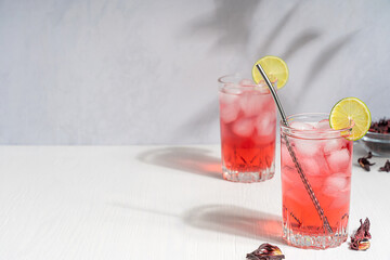 Cold refreshing hibiscus herbal iced tea made of dried flowers of red color with tart flavor served...