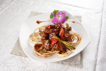 Stir fried spicy wagyu beef steak meat with onion vegetable in black pepper sauce on white background Asia halal menu
