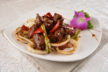 Stir fried spicy wagyu beef steak meat with onion vegetable in black pepper sauce on white background Asia halal menu