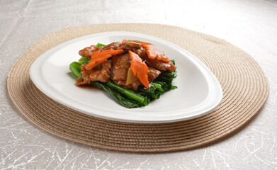 Stir fried vegetables with slices wagyu beef meat in dark soy sauce on white background Asia halal menu