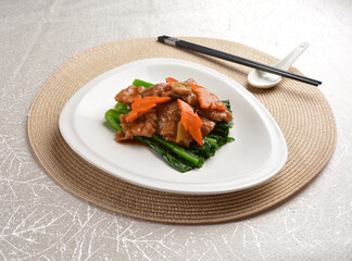 Stir fried vegetables with slices wagyu beef meat in dark soy sauce on white background Asia halal menu