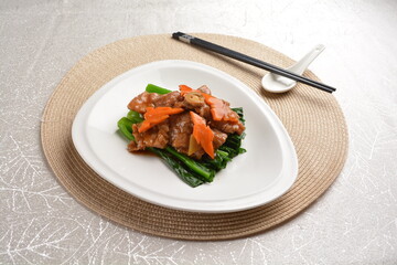 Stir fried vegetables with slices wagyu beef meat in dark soy sauce on white background Asia halal menu