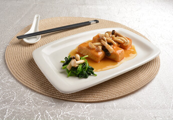 steam Home made bean curd tofu with mushroom on top with oyster sauce on white background Asia halal menu