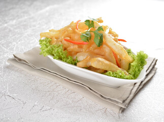 Deep fried crispy mini silver fish seafood snack with vegetables in white background Asia appetiser halal menu