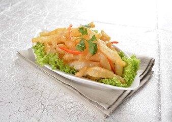 Deep fried crispy mini silver fish seafood snack with vegetables in white background Asia appetiser halal menu