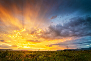 Majestic summer sunset with colorful clouds and sunrays