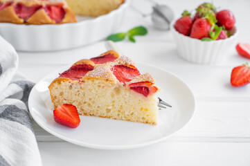 Strawberry sponge cake or pie on a white wooden background with fresh strawberries. Summer dessert. Copy space.