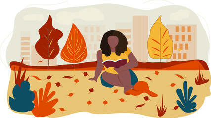 Beautiful woman with afro hairstyle reading a book in the autumn park.