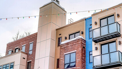 Pano Facade of modern townhouses with snowy flat roof and stairs at front entrances
