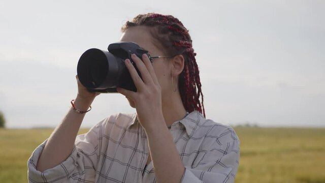 Close up view of a girl with big black camera in her hands