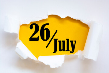 July 26. 26th day of the month, calendar date. Hole in paper with edges torn off. Yellow background...