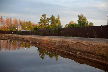 A pond excavated in the city. Water and shore. The lake at sunset.