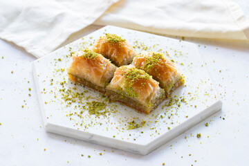 Baklava with pistachio on a white wooden background. Baklava on a marble floor