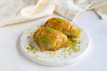 Sobiyet baklava with pistachio on a white wooden background. Baklava on a marble floor.