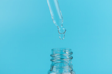 face serum drop with bottle on blue background.